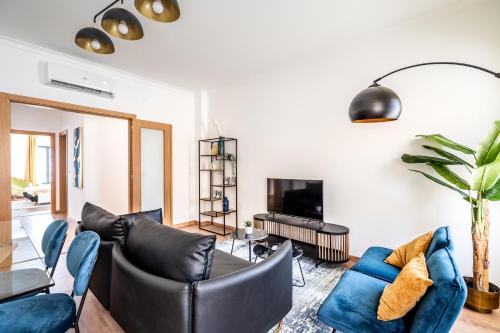 a living room with black leather furniture and a tv at Akisol Portalegre Charm in Ponte de Sor