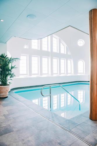 a swimming pool in a building with a large window at Slottsholmen Hotell och Restaurang in Västervik
