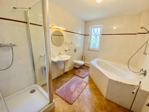 La salle de bains est pourvue d'une douche, d'une baignoire et d'un lavabo. dans l'établissement Lieblings Meerchen, à Warnemünde