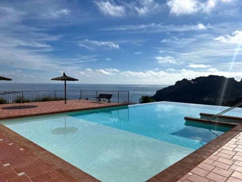 a large swimming pool with a view of the ocean at Apartamento Isla del Fraile in Águilas