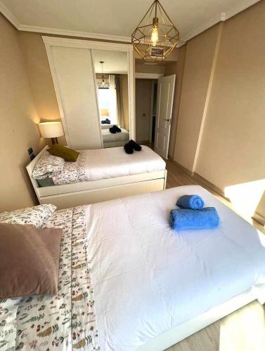 a bedroom with two beds and a mirror at Apartamento Isla del Fraile in Águilas