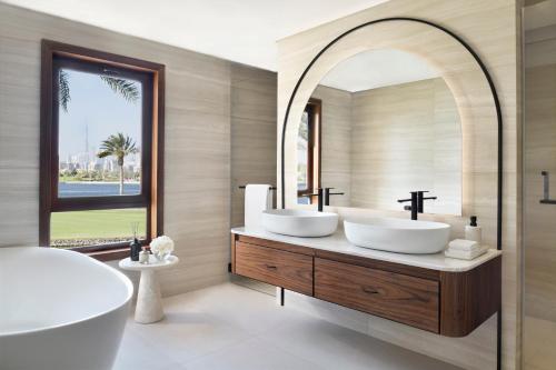 a bathroom with two sinks and a large mirror at Elara Villas in Dubai
