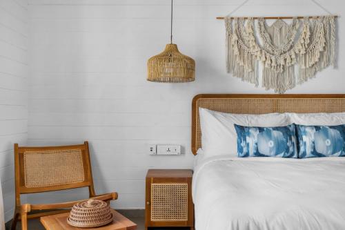 a bedroom with a bed and a chair at Azora by Ayatana, Goa in Morjim