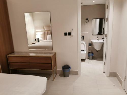 a bathroom with a mirror and a bed and a sink at شقة فاخرة بالقرب من البوليفارد A13 in Riyadh