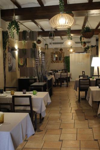 a restaurant with white tables and chairs and a room at Hotel La Villa in Requena