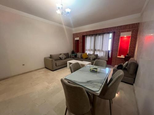 uma sala de estar com uma mesa e um sofá em appartement haut standing em Agadir