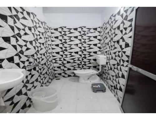 uma casa de banho com uma parede em azulejo preto e branco em Bisman Lodge, Jabalpur em Jabalpur