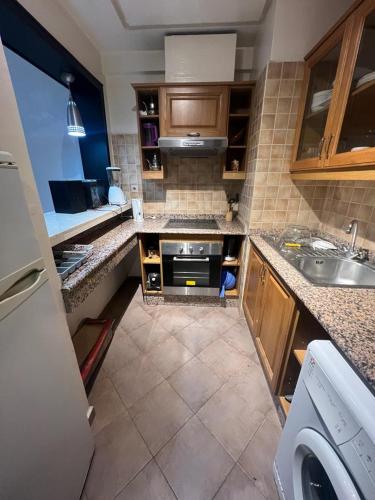 uma cozinha com um lavatório e um fogão em appartement haut standing em Agadir