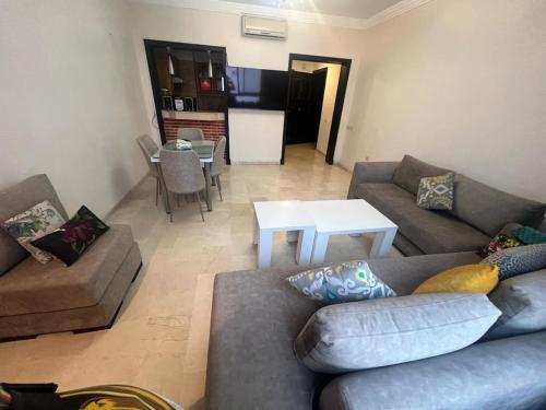 uma sala de estar com um sofá e uma mesa em appartement haut standing em Agadir