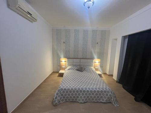 um quarto com uma cama com duas luzes em appartement haut standing em Agadir