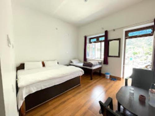 um quarto com uma cama e uma secretária. em Green Mountain Homestay Munshyari em Munsyari