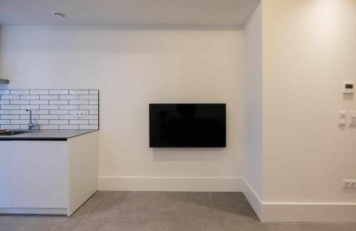 a television on a white wall in a room at AT Presidente Nº1 apartamento privado completo in Seville