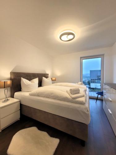ein Schlafzimmer mit einem großen Bett und einem großen Fenster in der Unterkunft Winterberg Appartement 21128 in Winterberg