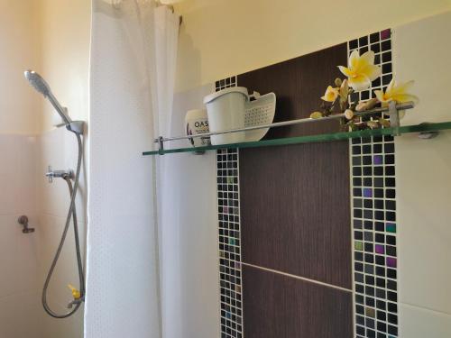 a bathroom with a shower with a glass tile wall at Links Sunset Beach House in Amphoe Koksamui