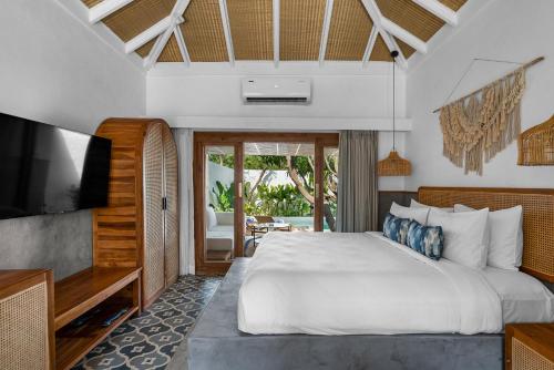 a bedroom with a large bed and a flat screen tv at Azora by Ayatana, Goa in Morjim