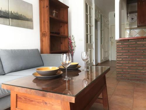 sala de estar con mesa y 2 copas de vino en Acogedor apartamento en Málaga centro, en Málaga