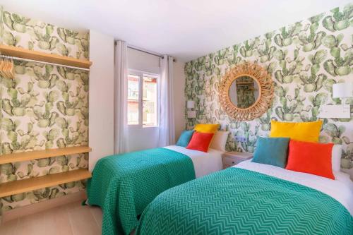 Duas camas num quarto com papel de parede floral em Vivendos New y Luxury apartment city center em Torremolinos