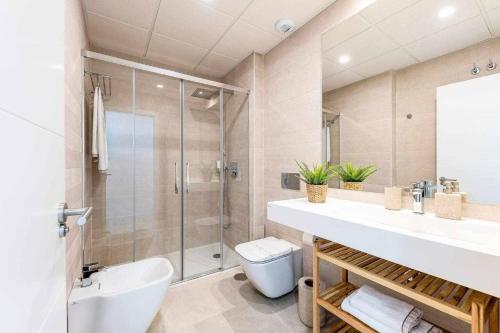 a bathroom with a shower and a sink and a toilet at Vivendos Lujoso apartamento de playa in Torremolinos