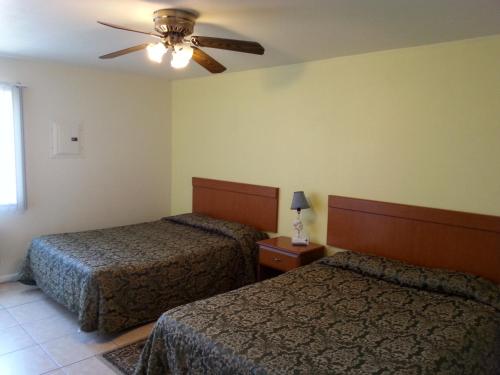 um quarto de hotel com 2 camas e uma ventoinha de tecto em Sunrise Motel em Seaside Heights