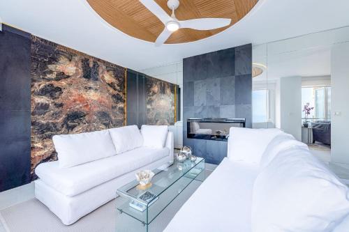 un soggiorno con divano bianco e TV di Vivendos Rocachica Premium frente al Mar a Torremolinos