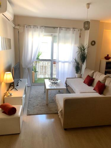 sala de estar con 2 camas y sofá en Bonito Apartamento en la Macarena en Sevilla