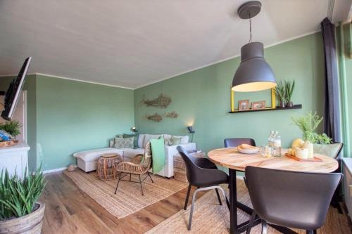 uma sala de estar com uma mesa e um sofá em Ferienpark - Haus M, App 0MEG08 em Heiligenhafen