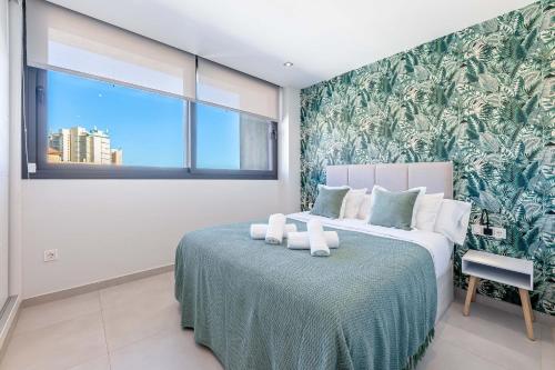 Vivendos - Luxury Duplex with Private pool في توريمولينوس: غرفة نوم مع سرير جدارية خضراء وبيضاء