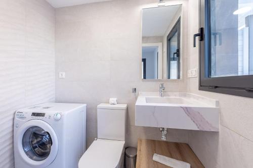 bagno con lavatrice e lavandino di Vivendos - Luxury Duplex with Private pool a Torremolinos