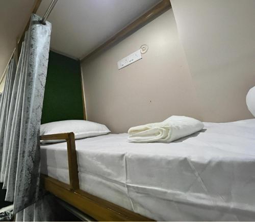 瓦拉納西的住宿－Shree Madhvam AC Dormitory，一间卧室配有两张带白色床单的床