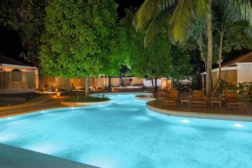 a large swimming pool at night with blue lights at Azora by Ayatana, Goa in Morjim