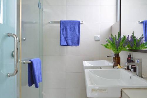 a bathroom with a sink and a shower with blue towels at 2000sq ft 186平米Luxury Residence in IMAGO Mall, KK in Kota Kinabalu