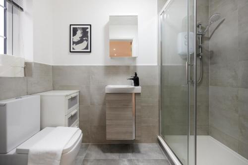 a bathroom with a shower and a toilet and a sink at The Redbridge Sanctuary - Spacious 3BDR House with Garden in London