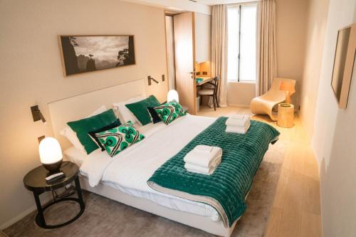 - une chambre avec un grand lit et des oreillers verts dans l'établissement Superbe Penthouse 3 Chambres Hammam Terrasse, à Paris