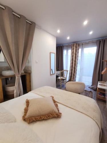 een slaapkamer met een groot wit bed in een kamer bij Au Poème du Chêne, Logement indépendant, Intimité, SPA et bien-être in Basse-Goulaine