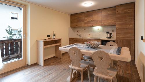 a dining room with a table and chairs and a kitchen at Chalet Li Mina in Livigno