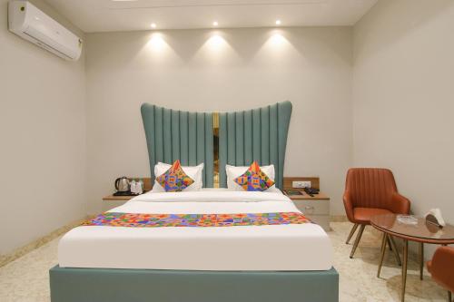 a bed with a blue headboard in a room at FabHotel Prime Royal Court in Ludhiana