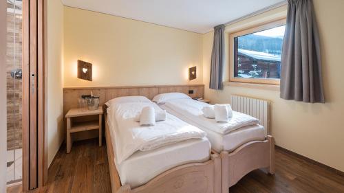 利維尼奧的住宿－Chalet Li Mina，带窗户的客房内设有两张单人床。