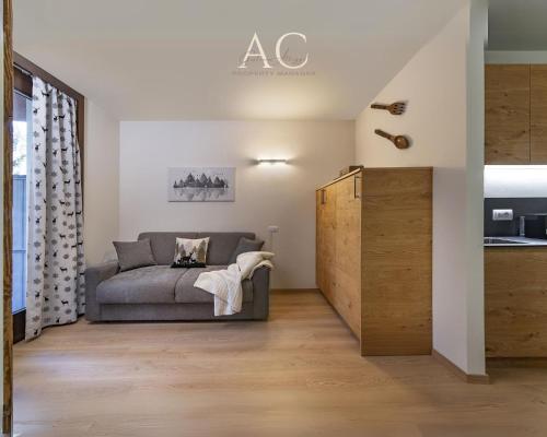ein Wohnzimmer mit einem Sofa und einer Küche in der Unterkunft Appartamento Mirella Wood in Ponte di Legno