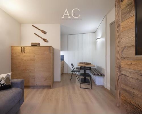 ein Wohnzimmer mit einem kleinen Tisch und einer Küche in der Unterkunft Appartamento Mirella Wood in Ponte di Legno