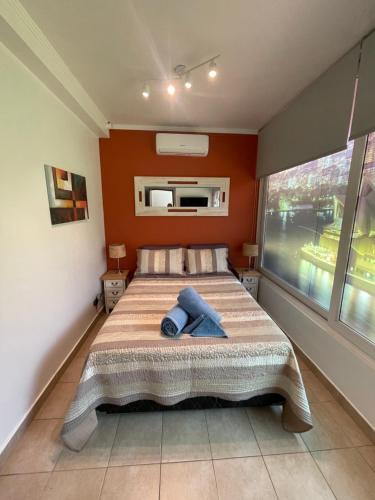 um quarto com uma cama com paredes cor de laranja e uma janela em Apartamento/Estudio en Las Condes em Santiago