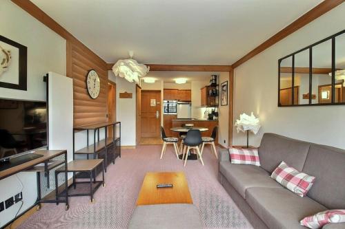 un salon avec un canapé et une salle à manger dans l'établissement ARC 1950 - APPARTEMENT MODERNE - SAUNA HAMMAM JACUZZI - 4 Personnes, à Arc 1950
