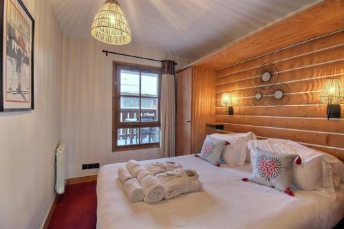 a bedroom with a bed with towels on it at ARC 1950 - APPARTEMENT MODERNE - SAUNA HAMMAM JACUZZI - 4 Personnes in Arc 1950