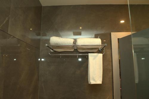 a bathroom with a towel rack with towels at Hotel Tanisha in Kishanganj Bazar