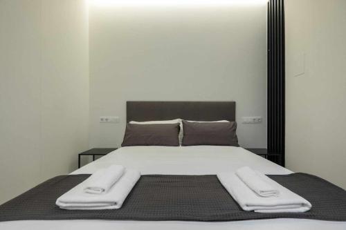 un letto con due asciugamani sopra di AT Presidente Nº2 apartamento privado completo a Siviglia