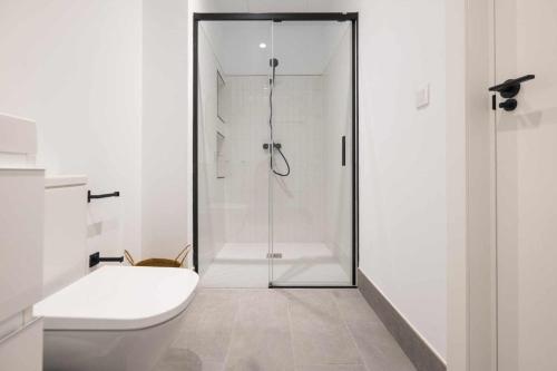 a white bathroom with a shower and a toilet at AT Presidente Nº2 apartamento privado completo in Seville