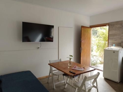 een eetkamer met een tafel en een televisie aan de muur bij OstendeZen in Ostende