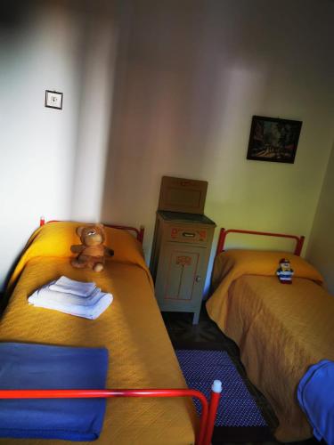 ein Schlafzimmer mit 2 Betten mit einem Teddybär oben drauf in der Unterkunft Casa immersa nella natura in Capanne di Sillano
