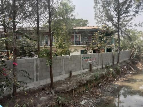 una pared de retención frente a una casa en Prakrity Village Resort Sundarbans, en Gosāba