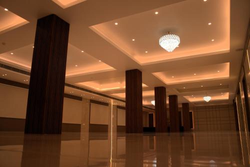 a lobby with columns and a chandelier in a building at Hotel Tanisha in Kishanganj Bazar