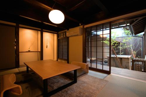 a living room with a wooden table and a window at NIPPONIA HOTEL Ozu Castle Town in Ōzu